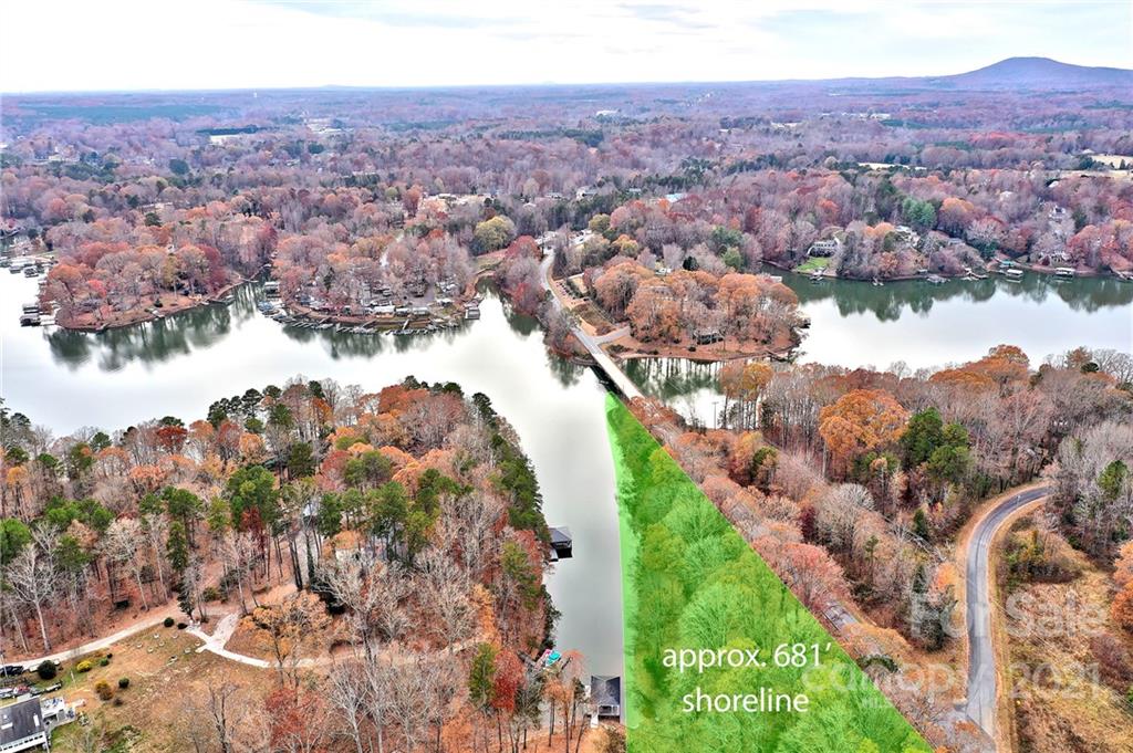 Aerial view of lake shoreline in autumn landscape.