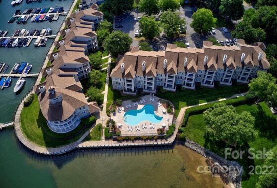 Aerial view of waterfront condos with a pool.