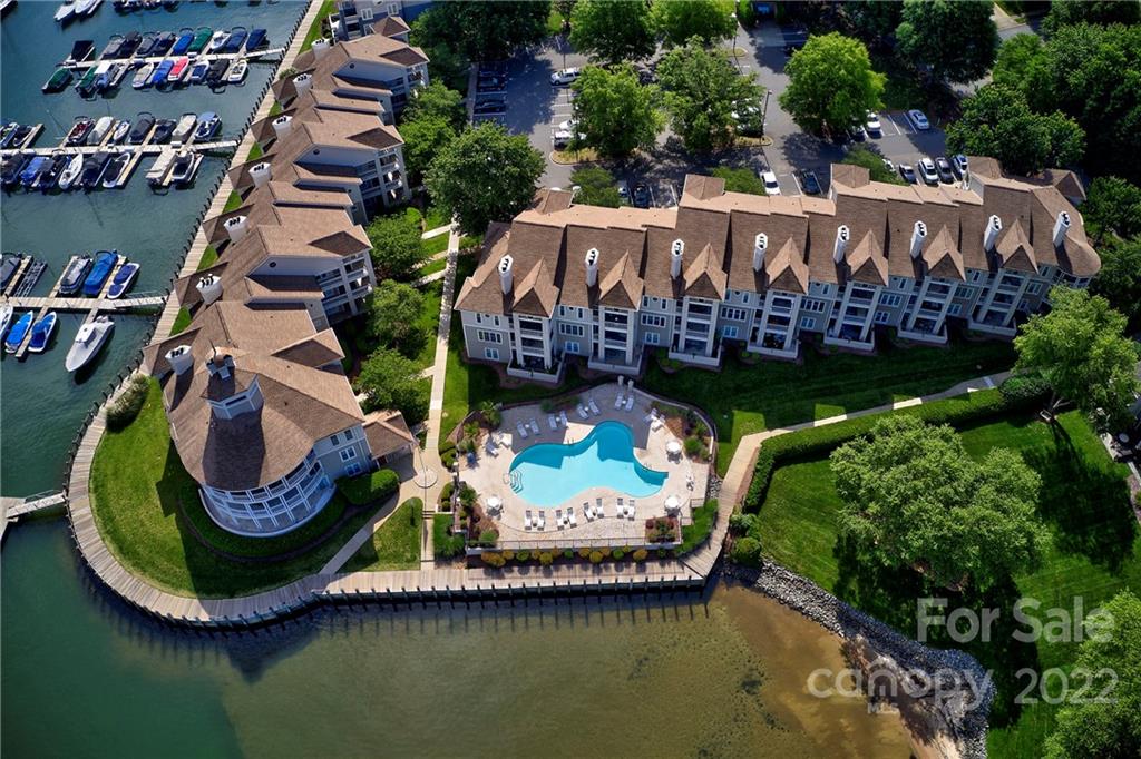 Aerial view of waterfront condos with a pool.