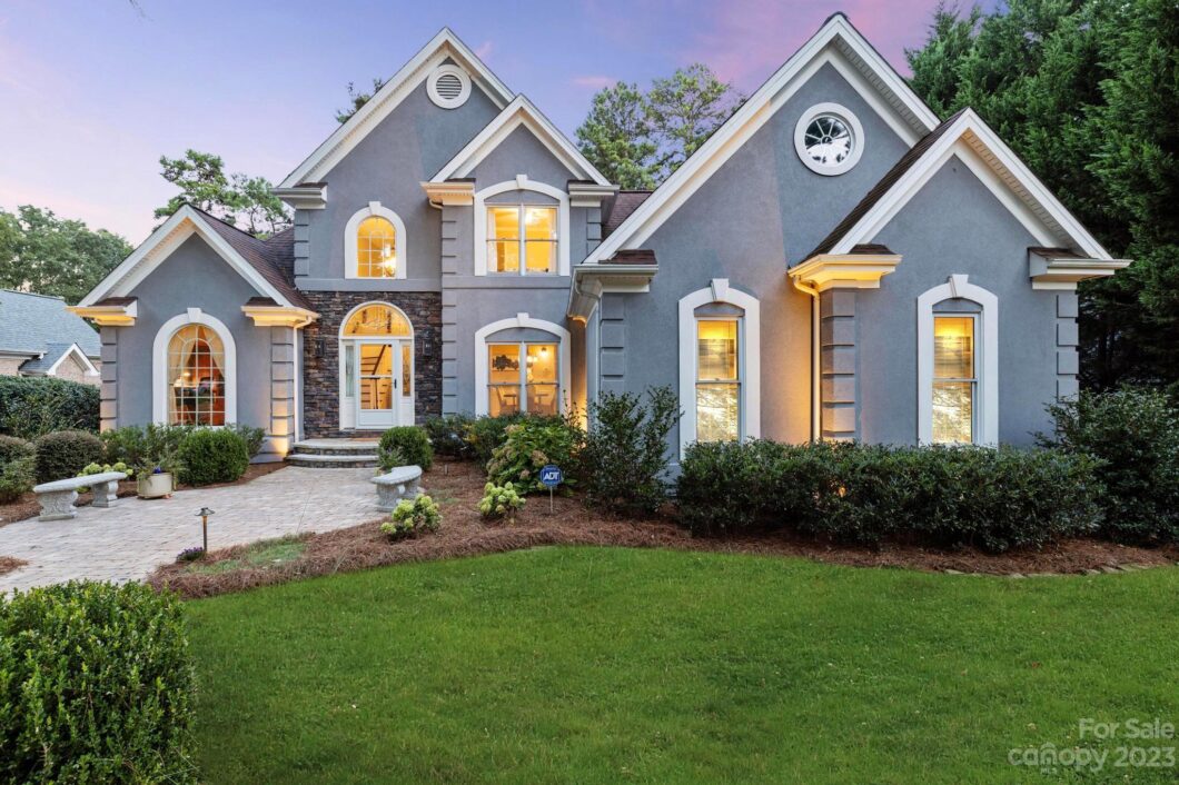 Elegant gray suburban house with arched windows.