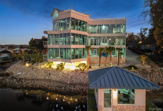 Modern lakeside house with glass facade at dusk.