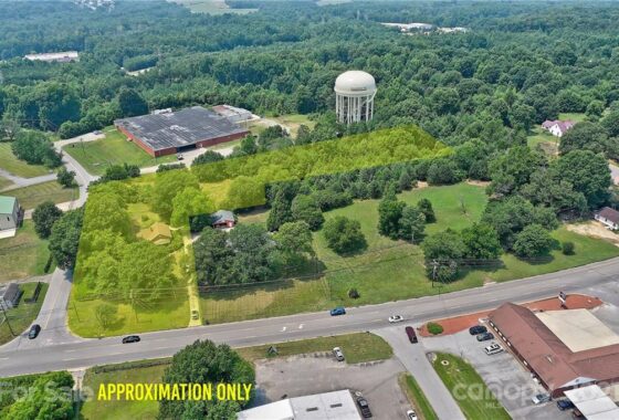 Aerial view of land and buildings marked for sale.