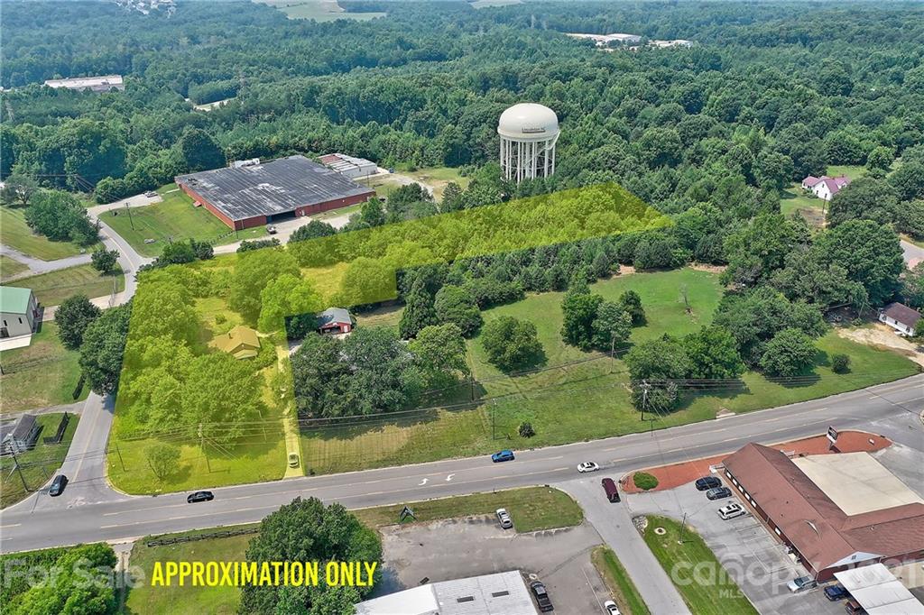 Aerial view of land and buildings marked for sale.