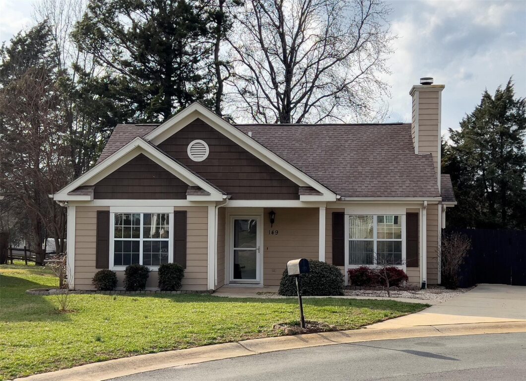 Cozy suburban house with green lawn and mailbox.