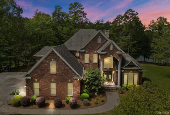 Brick house at twilight with lush landscaping.